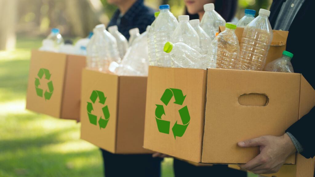 people holding boxes of recyclable plastic containers.