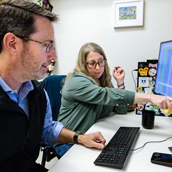 Texas A&M researchers Dr. Bill Murphy and Dr. Nicole Foley looking at a computer screen