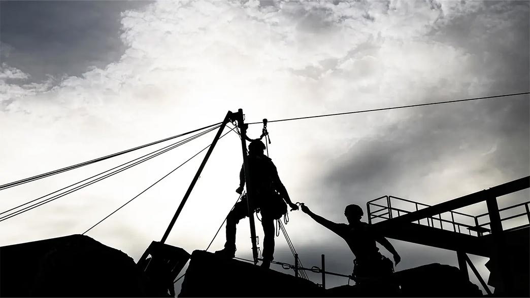 Search and rescue first responders silhouetted against a stormy sky